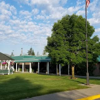 A welcoming building surrounded by greenery and a flag waving in the breeze.