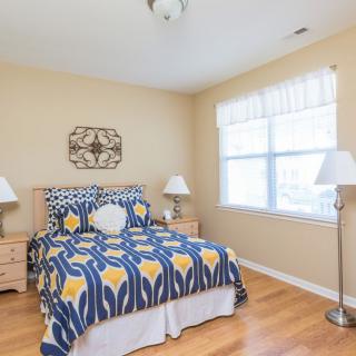 A cozy bedroom with patterned bedding and natural light.