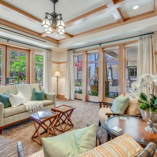 A cozy and modern living room with ample natural light, featuring comfortable seating and stylish furnishings.