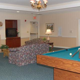 A spacious living room with a pool table, sofa, and television.