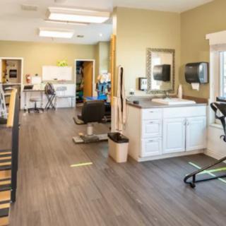 A spacious rehabilitation center equipped with exercise machines and therapy stations.