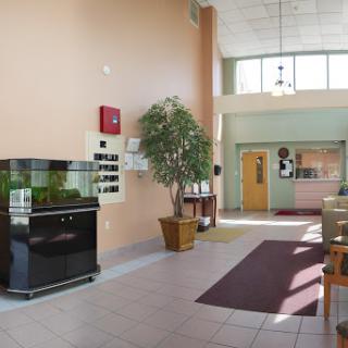 A spacious and inviting lobby featuring an aquarium, plants, and comfortable seating.