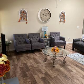 A cozy living room with gray sofas, a glass coffee table, and decorative wall art.