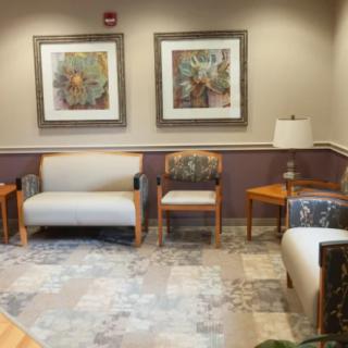 A cozy waiting room with comfortable seating and framed artwork on the walls.