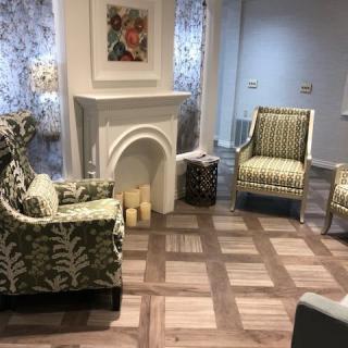 A cozy living room with patterned armchairs and a decorative fireplace.