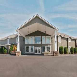 A large hotel building with a prominent entrance under a clear sky.