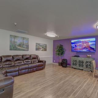 A cozy living room featuring a large couch, wall-mounted television, and hardwood floors.