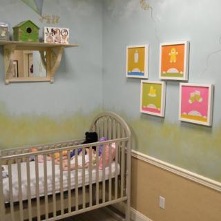 A cozy nursery featuring a crib and colorful wall art, perfect for a baby.