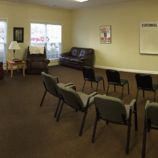 An empty waiting room with arranged seating and furniture.