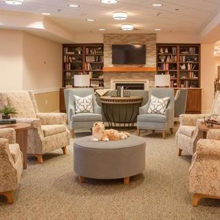 A cozy living room with comfortable seating, a fireplace, and bookshelves.