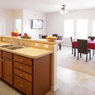 An open-concept kitchen with a dining area featuring a countertop, sink, and dining table with chairs.