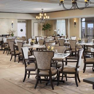 Spacious dining area with multiple tables and elegant chandeliers.