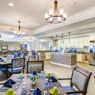 A beautifully decorated dining room with elegantly set tables and modern chandeliers.