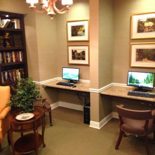 A cozy office space with two computer desks, a bookshelf, and decorative elements.