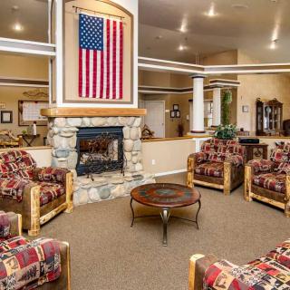 A cozy seating area with a stone fireplace and an American flag hanging above it.