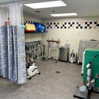 A view of a treatment room equipped for rehabilitation with various medical supplies and equipment.