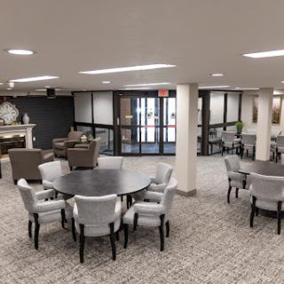 A spacious and modern lounge area featuring comfortable seating and tables for gatherings.