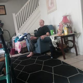 A person sitting comfortably in a living room, surrounded by home decor.