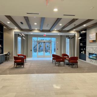 A modern lobby with comfortable seating and a fireplace.
