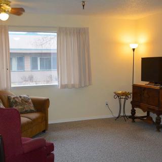 A cozy living room with a TV, lamp, and comfortable seating.