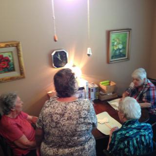 A group of seniors sitting around a table engaged in a discussion or activity.