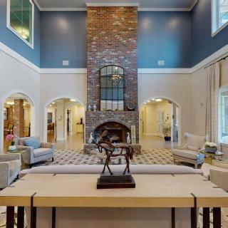 A luxurious living room with a vaulted ceiling and central fireplace, elegantly furnished.