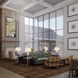 A modern lobby with a high ceiling, large windows, and elegant seating area.