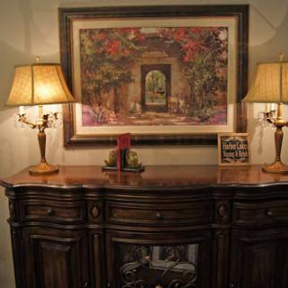 A tastefully decorated interior featuring a wooden sideboard, elegant lamps, and beautiful wall art.