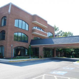 A modern brick building with large windows and a covered entrance.