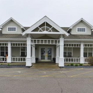 A white house with a distinctive porch and several windows.