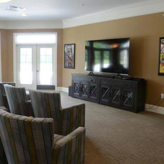 A cozy home theater setup with multiple chairs facing a large TV.