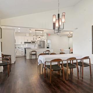 An elegant open-concept dining and kitchen area with modern furnishings and wooden flooring.
