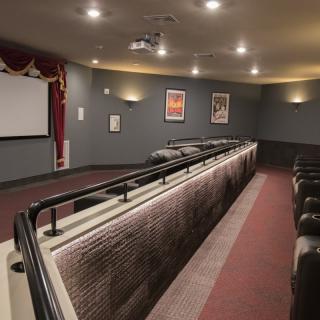 A cozy home theater room with comfortable seating and a large projector screen.