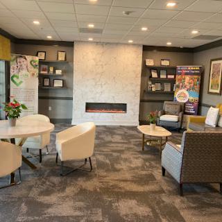 A comfortable and modern lounge area featuring a cozy fireplace, stylish seating arrangements, and decorative shelves.