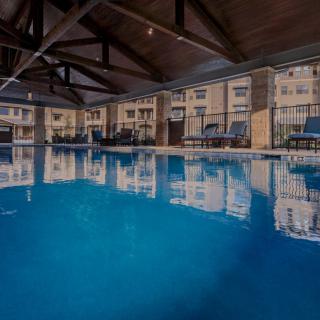 A spacious indoor swimming pool with lounge chairs lining the deck, providing a serene space for relaxation.