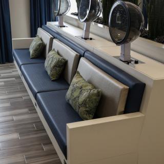 A salon seating area with hair dryers and comfortable cushions.