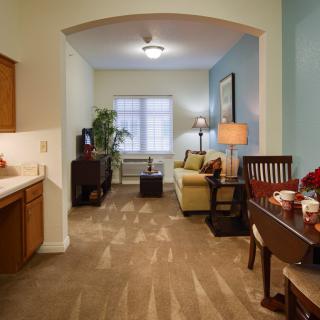 Cozy living and dining area with a sofa, dining table, and television.