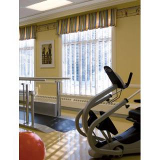 A gym interior with exercise equipment, including an elliptical machine and balance bars.