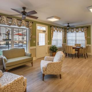 A cozy living area with comfortable seating, a dining table, and large windows that let in natural light.