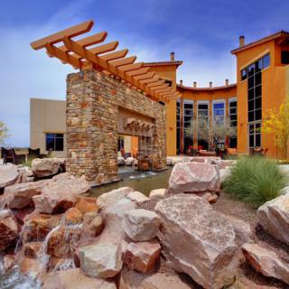 Outdoor view of a modern building with stone features and a water element.