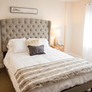A cozy bedroom with a tufted headboard and stylish decor.