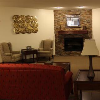 A cozy living room featuring a brick fireplace, comfortable seating, and decorative elements.