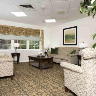 A cozy living room with patterned furniture, a large window, and decorative accents.