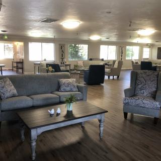 A spacious living room with modern decor, featuring comfortable seating and wooden floors.