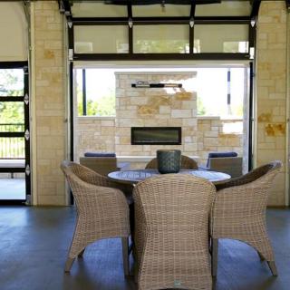 A cozy outdoor patio area with wicker chairs and a fireplace.