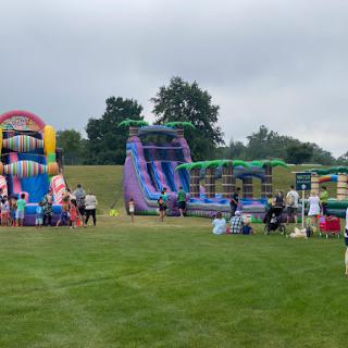 A fun-filled day at the outdoor inflatable playground, featuring colorful bouncy castles and water slides.