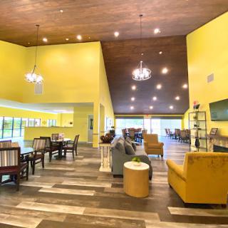 A bright and inviting lobby featuring modern decor with yellow walls and stylish furniture.