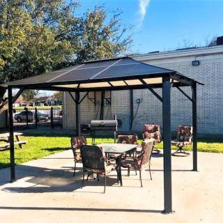 A sunny backyard with a gazebo and outdoor seating area.