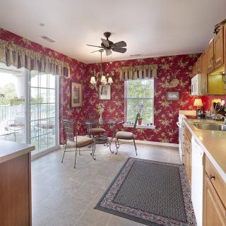 Cozy kitchen with red floral wallpaper and natural lighting.