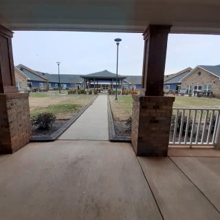 A covered walkway leading to a building in a landscaped area.
